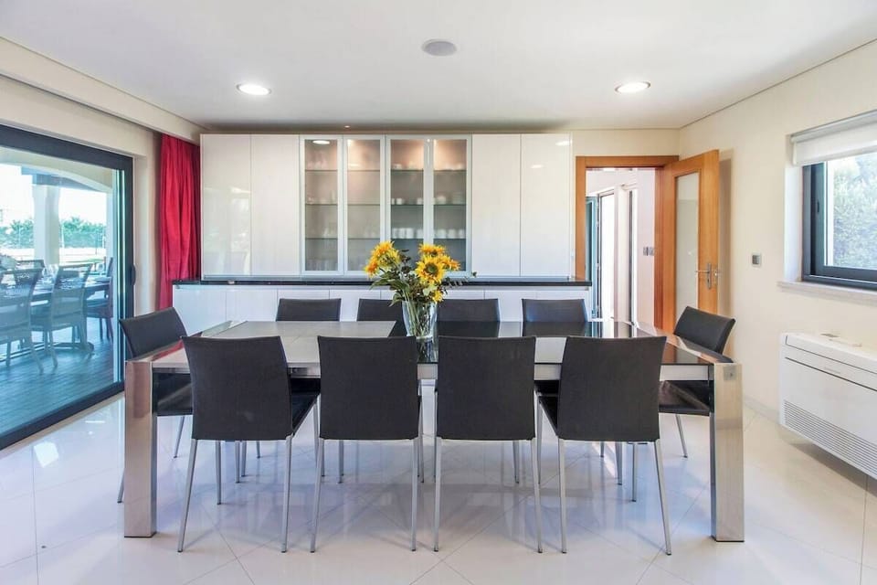 Modern dining room with glass-fronted cabinetry — Villa Aqua, luxury holiday villa in Grândola