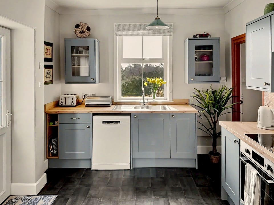 Kitchen has dishwasher, microwave, tall upright fridge, electric cooker and hob