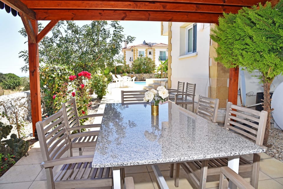 Pergola, grant table and chairs and garden view 