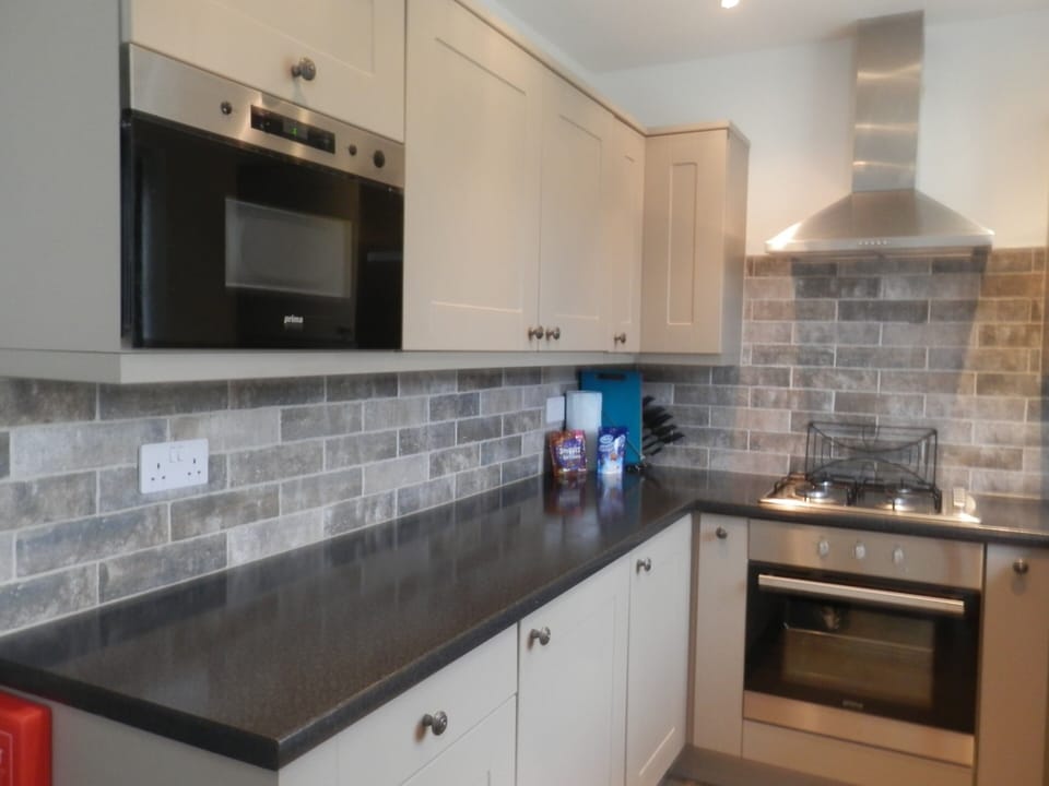 Microwave with cleaning equipment above, electric oven and gas hob