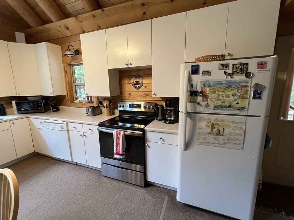 Kitchen includes glass topped electric stove, refrigerator, and dishwasher