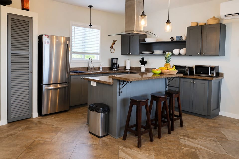Bright, fully equipped kitchen with stainless appliances, breakfast bar seating, and everything you need to prepare meals at home.