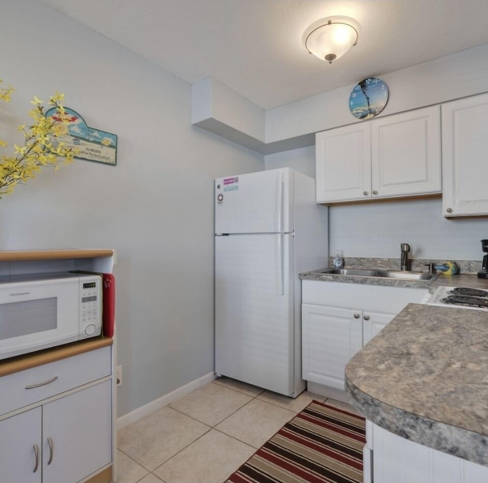 Kitchen with stove, refrigerator, microwave, toaster, coffeemaker, dishes, etc