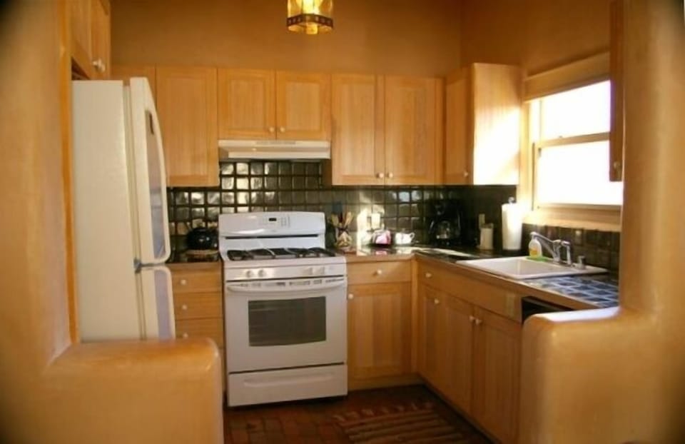 The sunny, fully-stocked kitchen features Mexican tile and a new stove.
