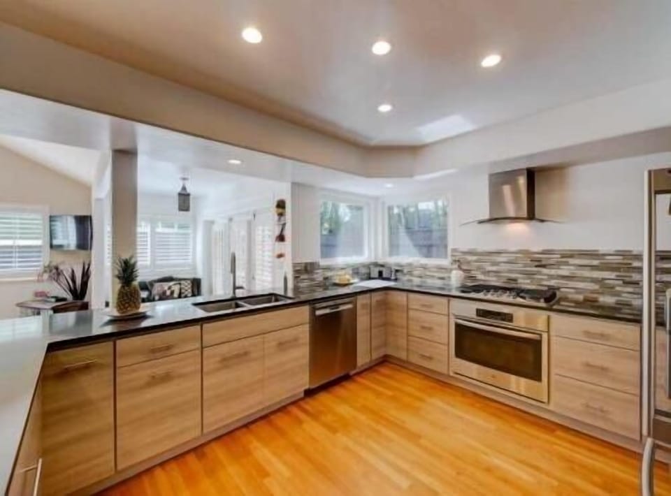View from kitchen looking out to rear family room/garden/deck/pool and hot tub