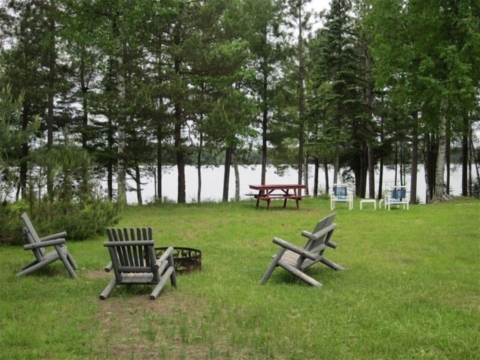 Large yard with fire pit, overlooking water. 