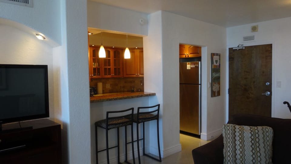 entrance into kitchen with 2 bar stools