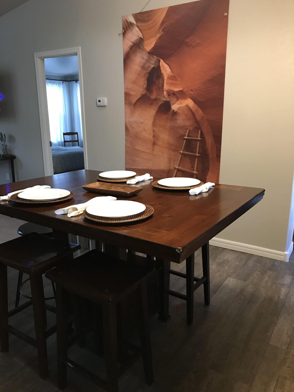 Kitchen table with counter height seating and place settings.