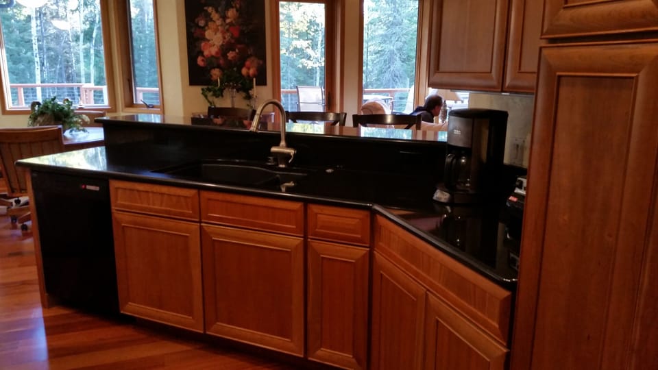 Bar, dishwasher and plenty of storage open to living room and view of back yard.