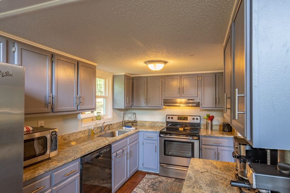 Dishwasher, stove, etc in the well-equipped kitchen.