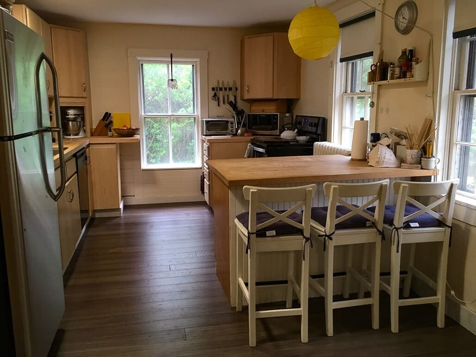 The kitchen with butcher block counters, mixer, blender, cuisinart, & microwave.