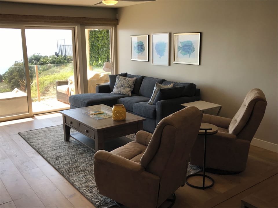 Enjoy beautiful ocean views while relaxing in comfortable living room seating.