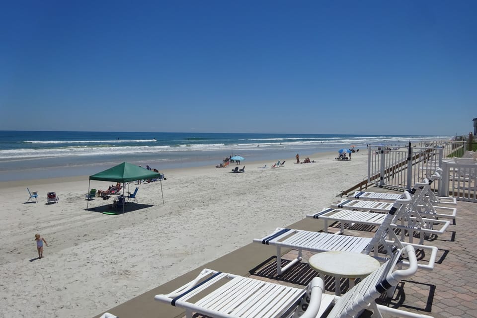 South east view of beach and surf from deck lounging area.