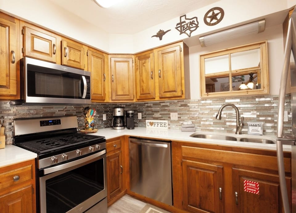 Cook your favorite meals in this fully equipped kitchen, featuring stainless steel appliances, ample counter space, and charming Texas-inspired décor that makes you feel right at home.