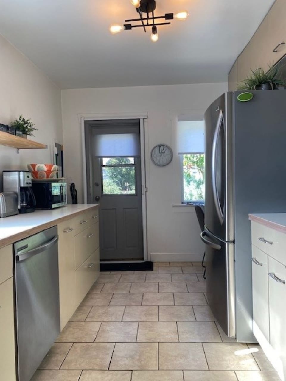 Open and updated galley style kitchen with new stainless steel appliances.