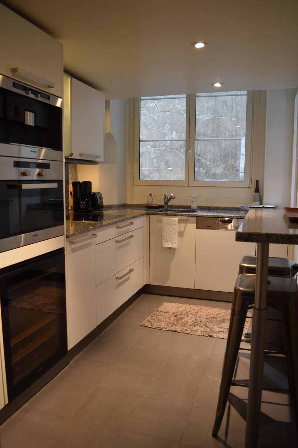 Gourmet kitchen with cooktop, steam oven, built-in coffee maker.