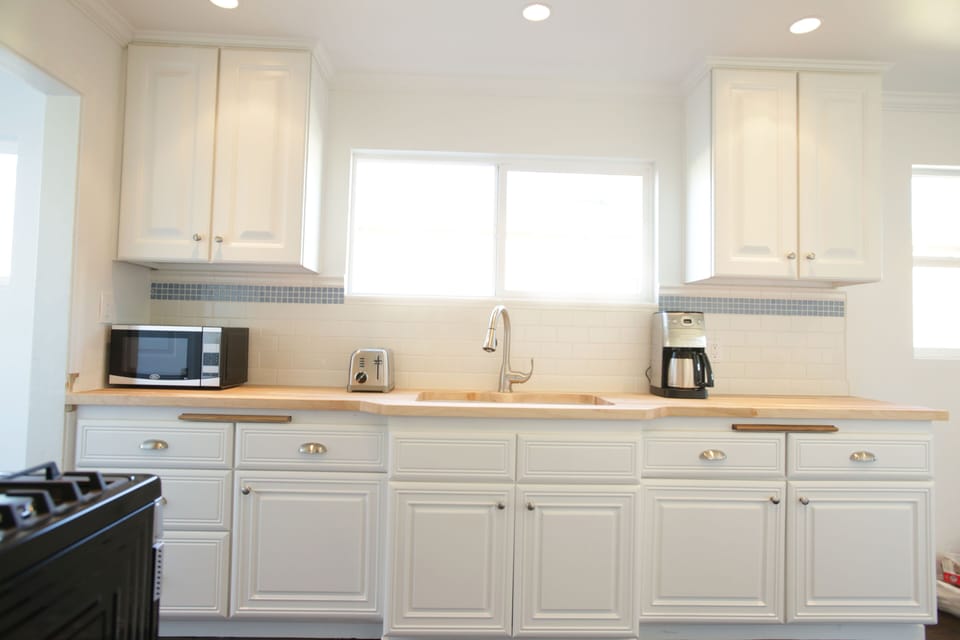 Brand new bright stainless steel kitchen. Microwave, coffee maker, stove, Fridge