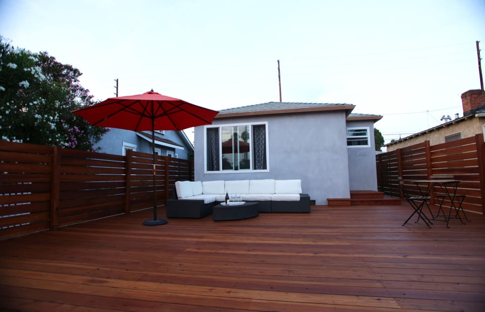 Front of house with 400 square foot private sundeck, sofa, and dining area