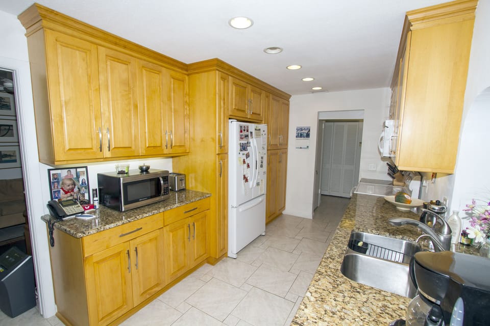Kitchen with lovely granite counter tops, large fridge, cabinets, microwave #2