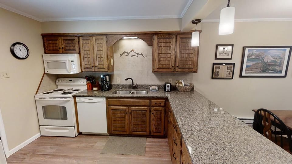 Cook your favorite meals in this fully equipped kitchen featuring granite countertops, a stove, microwave, and everything you need to feel right at home during your stay.