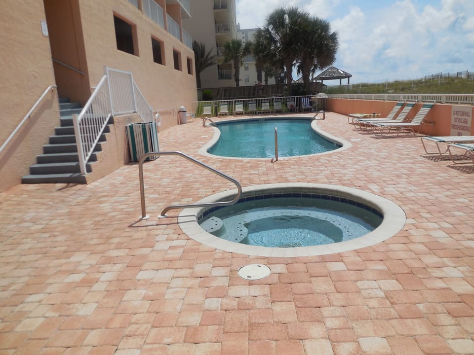 Pool and Hot tub with plenty of chairs for relaxing and soaking up the sun