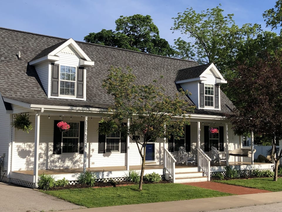 Front of house, porch with swing and 3 Adirondack chairs