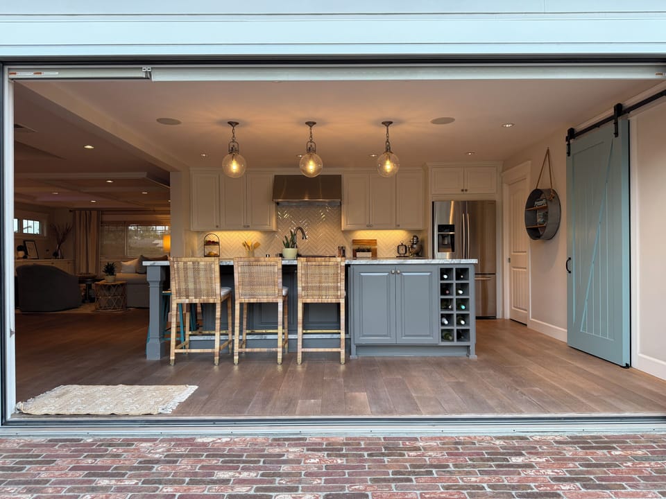 Entire kitchen wall of windows opens to bring the outside inside.