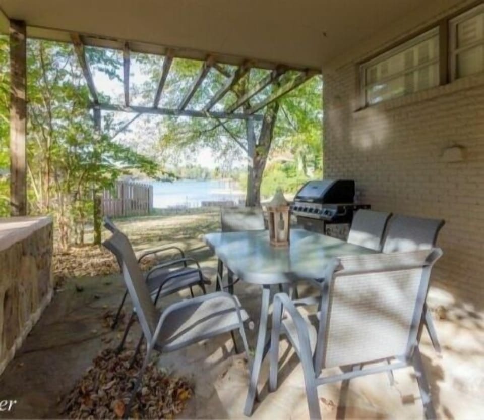 Side porch with covered dining with gas grill.