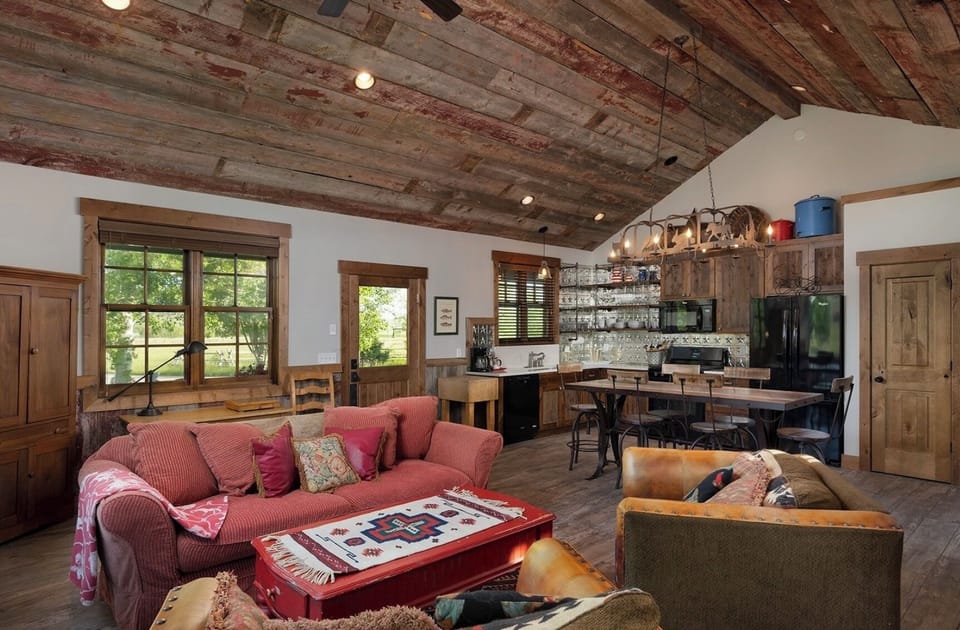 The great room has a 12-ft ceiling, large couch and cozy chairs.