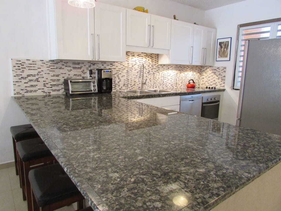 Large kitchen with granite counters, rock backsplash, and stainless appliances
