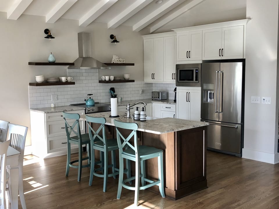 Leathered granite island with seating for 4 (3shown in picture) open shelving