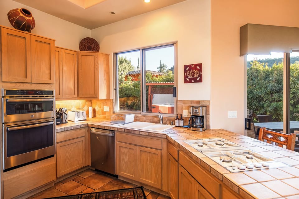 View of kitchen showing microwave, oven, dishwasher, and coffee maker.