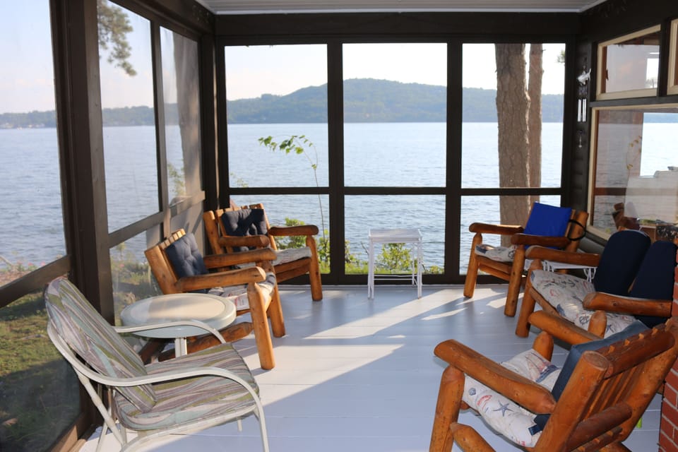 Screened porch with afternoon sun over Meredith 
Bay