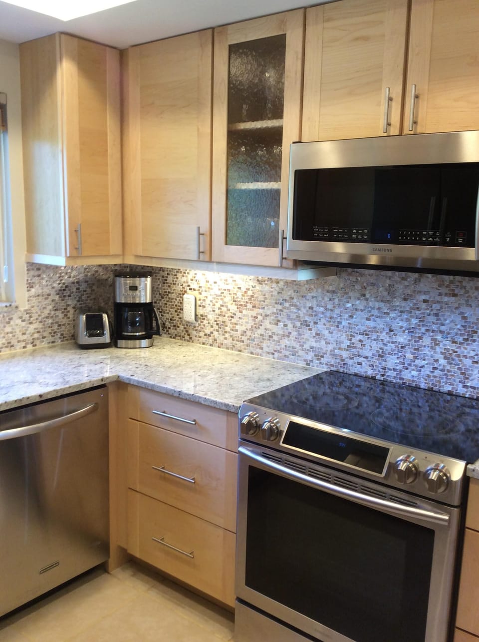 Plenty of small appliances, dishes, utensils and cookware in kitchen