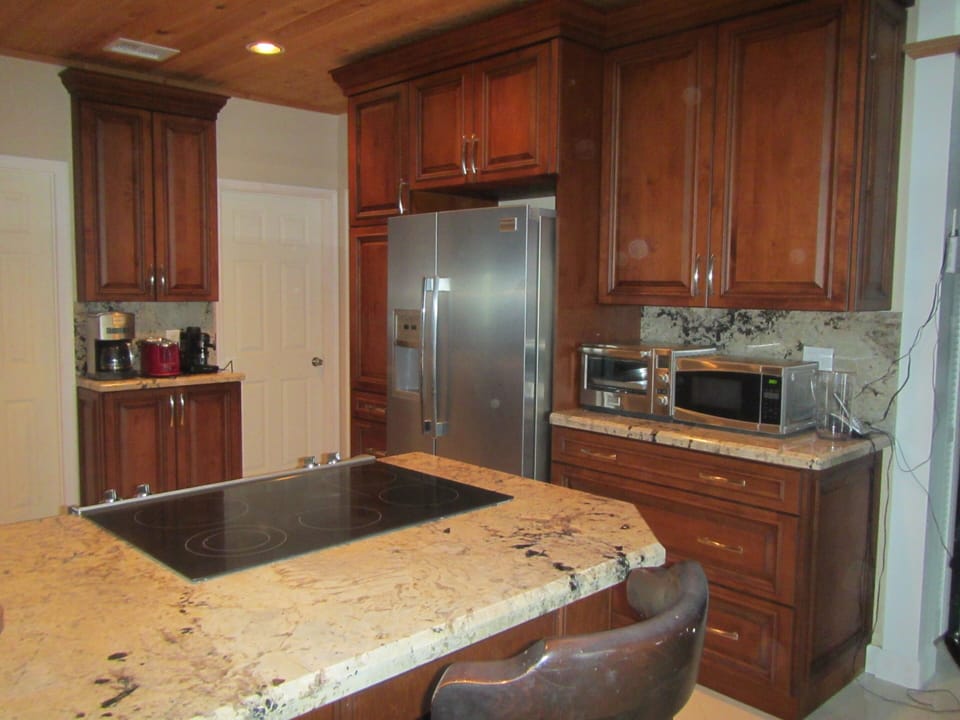 Cherry wood cabinets with complete cooking utensils, pots, pans, dishes, etc.