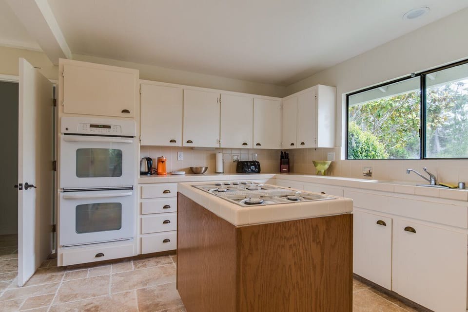 Kitchen with 2 ovens, island stove top, large refrigerator, dishwasher, etc