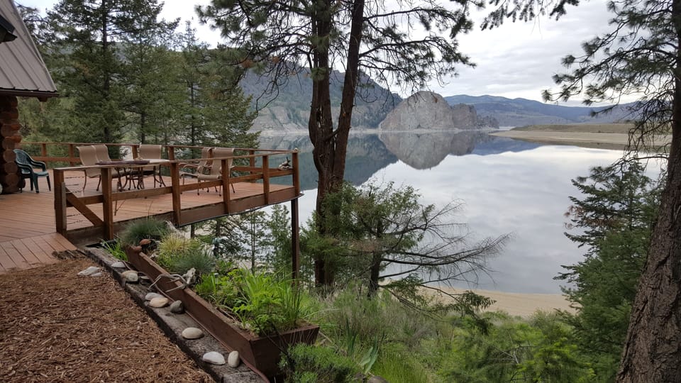 Cabin deck with view of lake and white stone rock