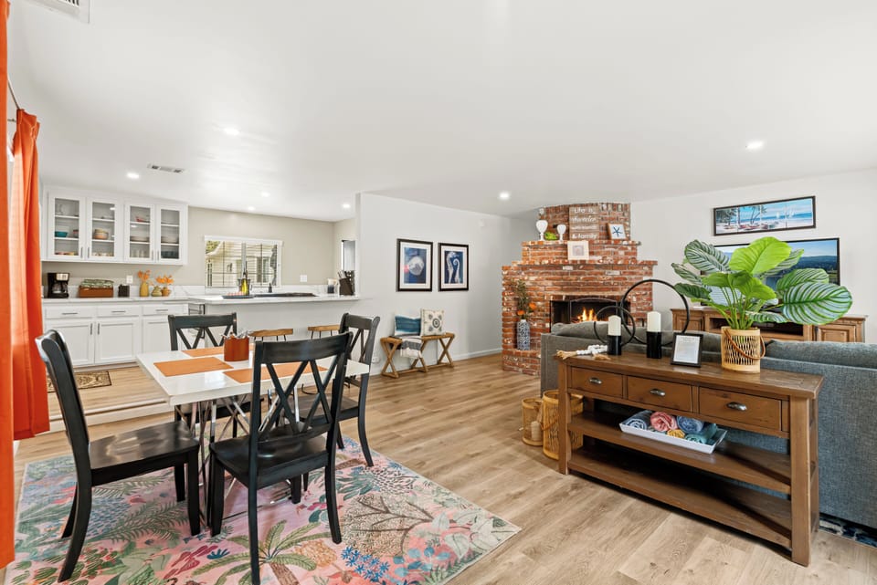 Welcome the open-concept living space, perfect for gathering around the cozy brick fireplace. The fully equipped kitchen and dining area flow into living room.