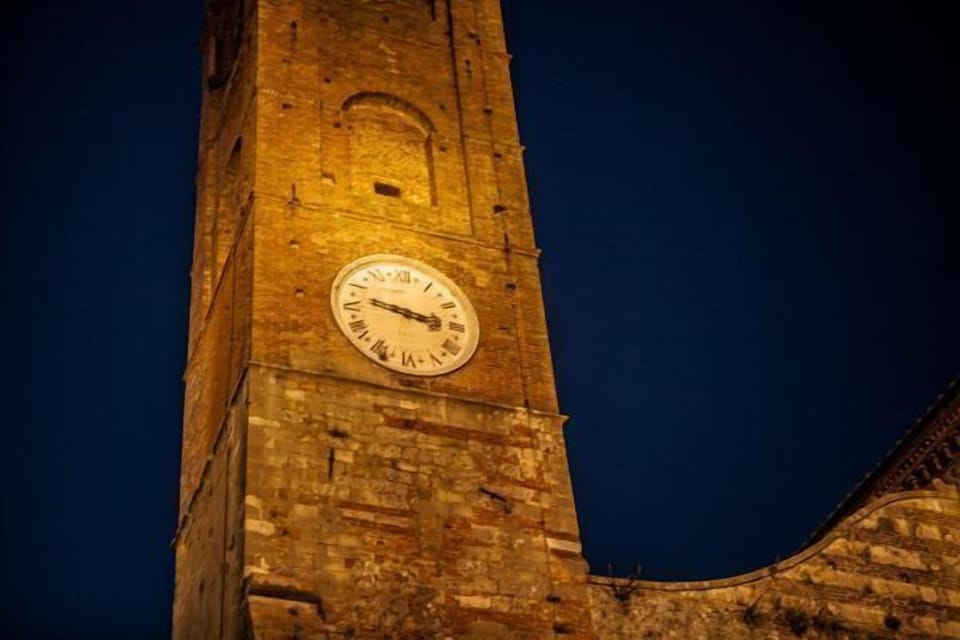 Clock tower in Chiesa Collegiata in the main village pizza overlooks an enoteca.