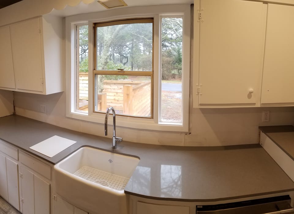 New Porcelain deep fitted country sink and washing machine to right.