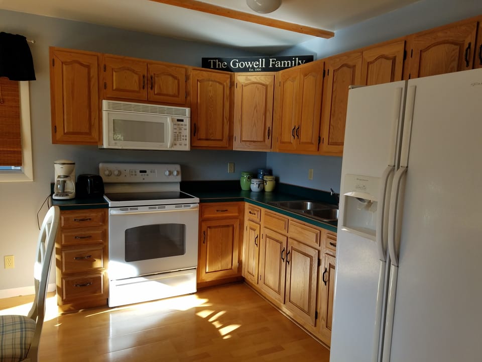 Kitchen includes stove, oven, microwave, fridge, toaster and coffee maker.