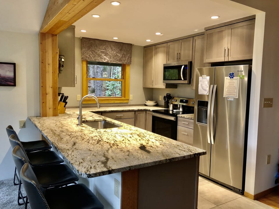 Brand new open kitchen with stainless steel appliances and leathered granite
