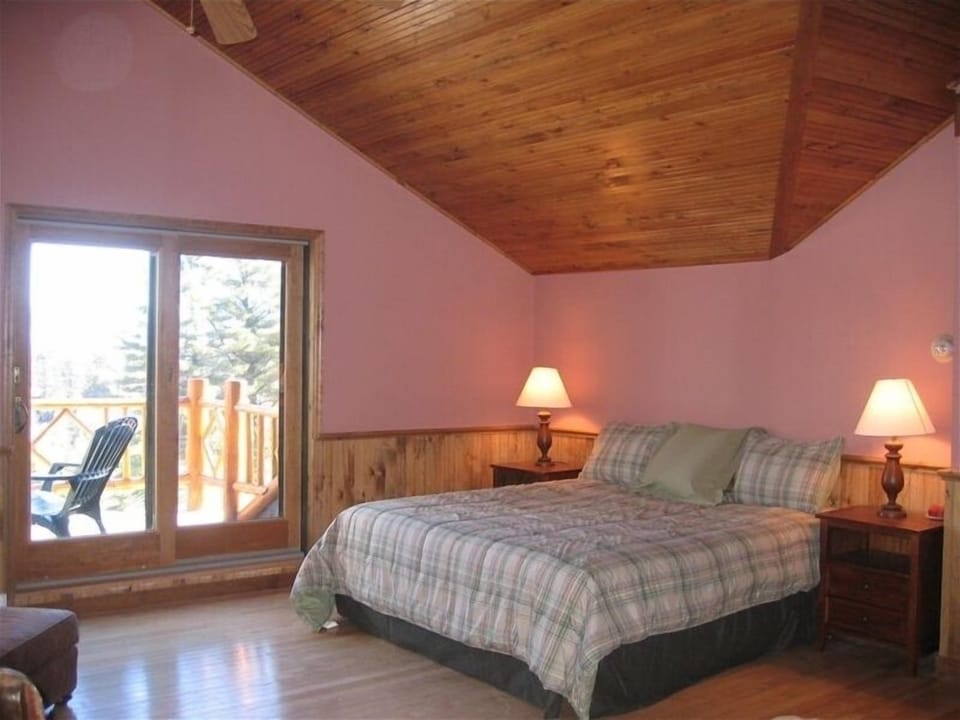 Master Bedroom with private balcony, private bath, and wood burning fireplace.