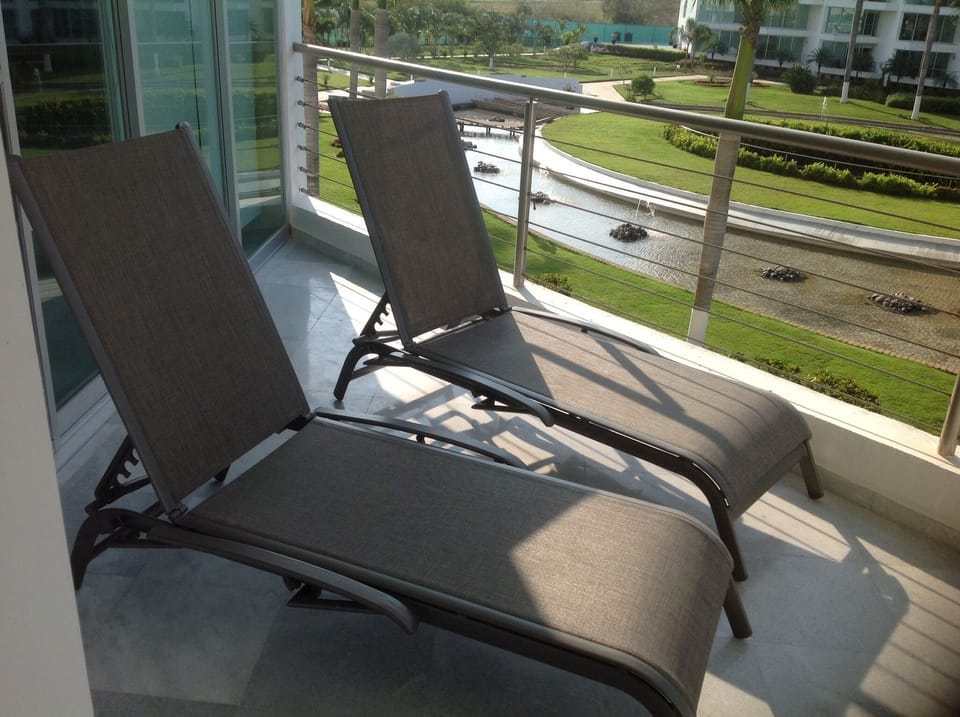 Master bedroom balcony with two lounge chairs