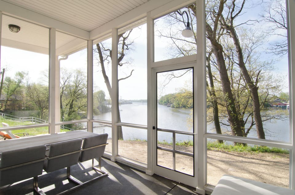 The view from inside the screened porch + outdoor dining table in main house.