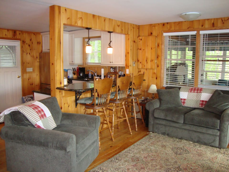 View towards kitchen from living room. Three barstools at counter. 