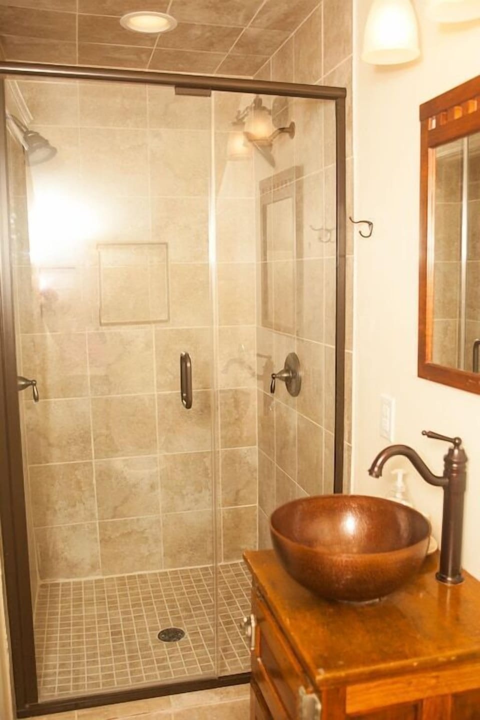 Large walk in shower with dual shower heads, and antique ice chest vanity