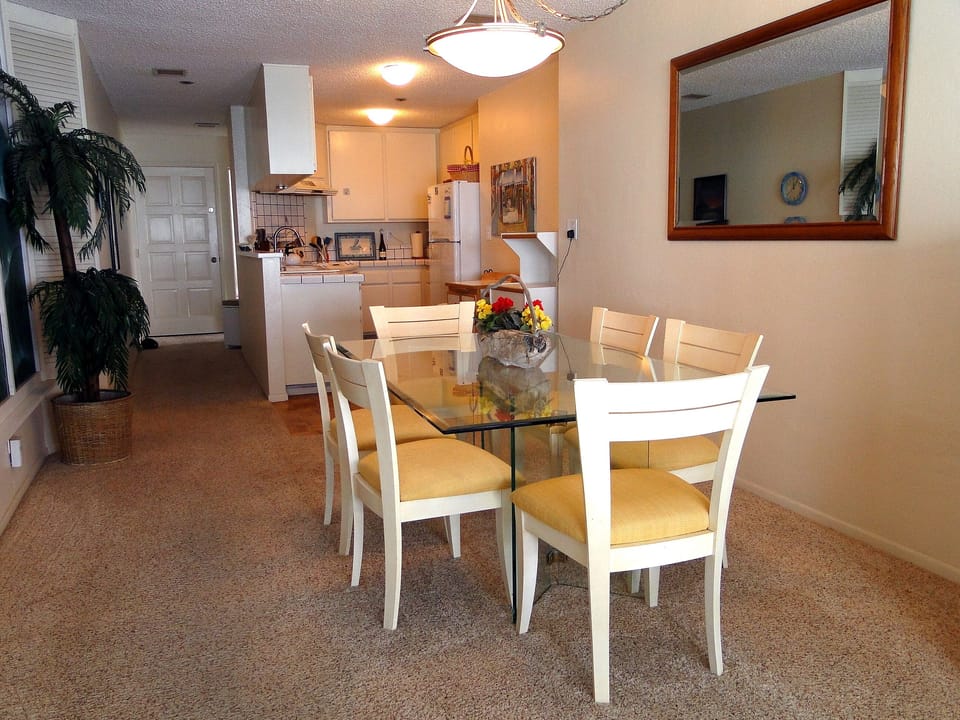 Dining room area with kitchen in the background.