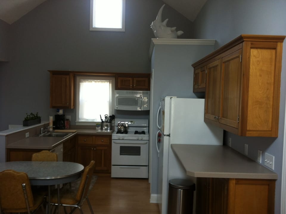 Stocked kitchen, dinner wares, cooking utensils, and cutlery. 