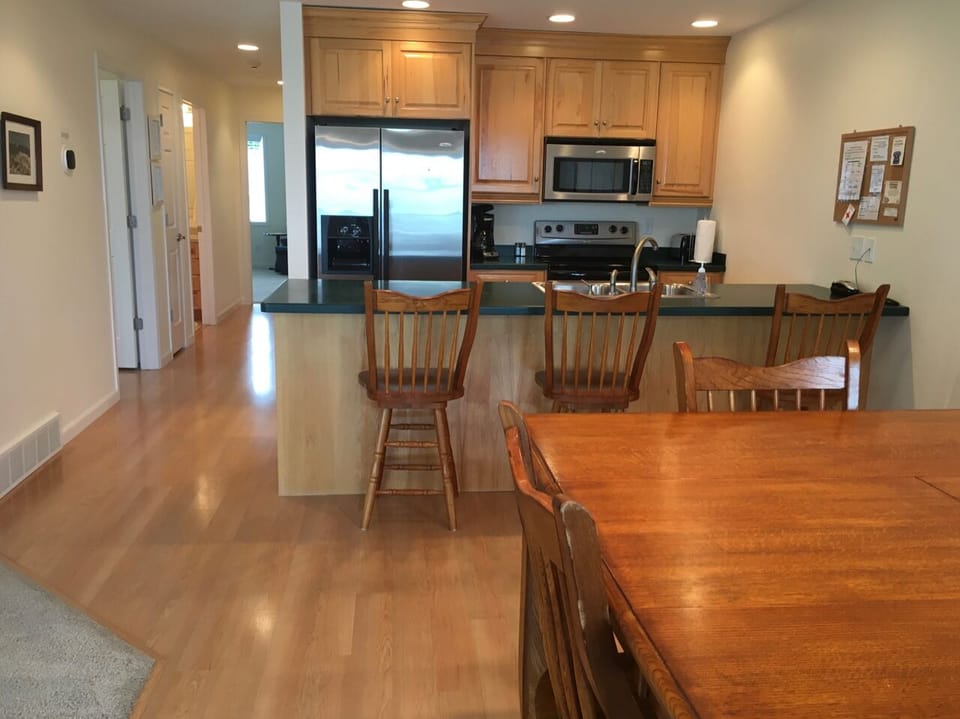 View of kitchen and hallway to bedrooms and bathrooms, from the dining area.